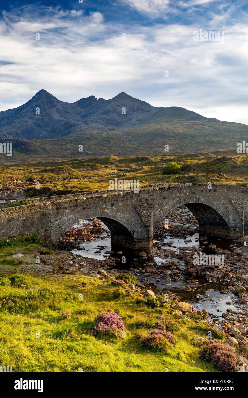 Il vecchio ponte di pietra sul fiume Slichagan con il nero montagne Cuillin oltre, Slichagan, Isola di Skye in Scozia Foto Stock