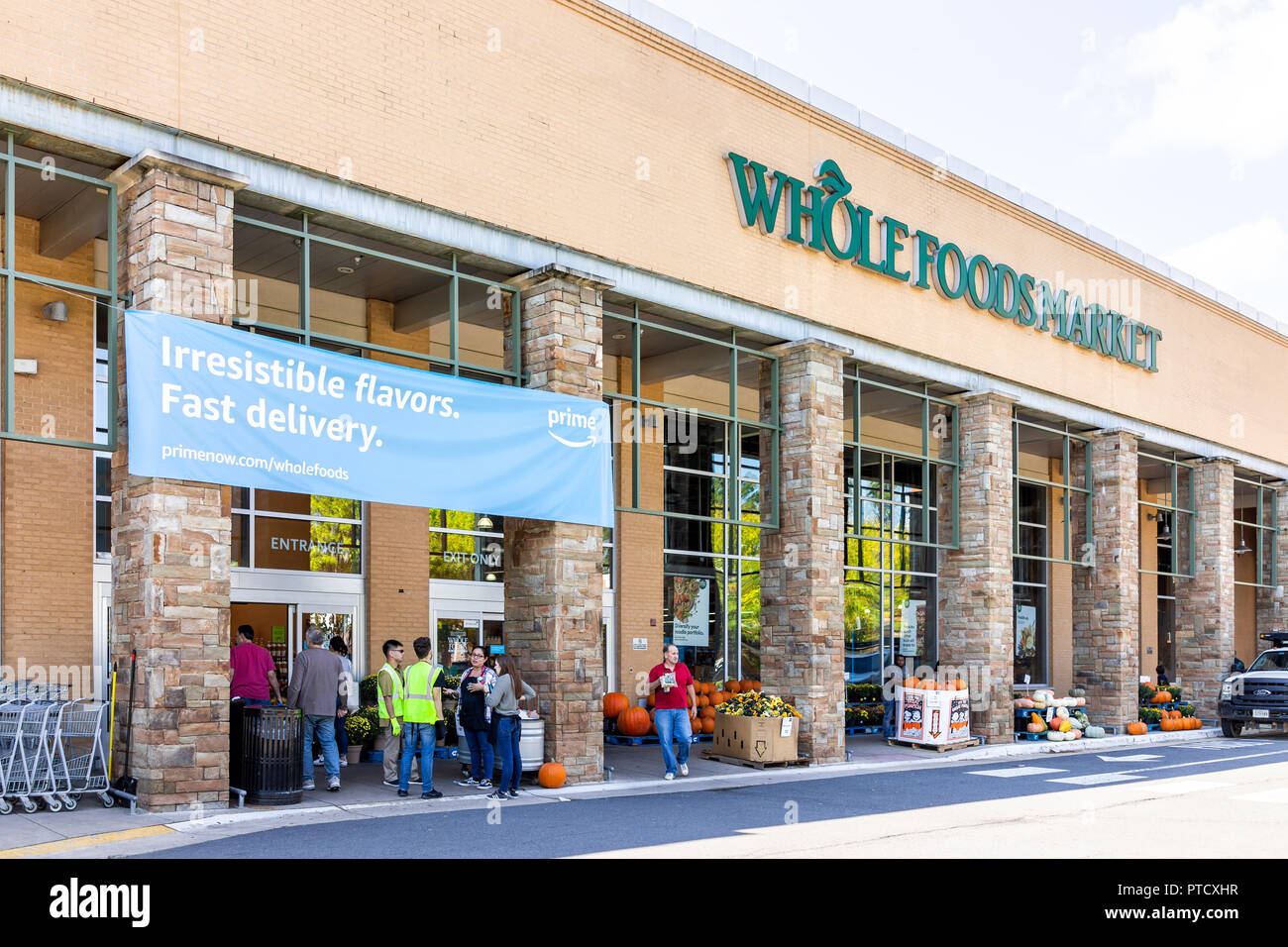 Fairfax, Stati Uniti d'America - 29 Settembre 2018: Whole Foods Market segno su edificio esterno in città in Virginia con persone, blue Amazon primo segno di consegna, entr Foto Stock
