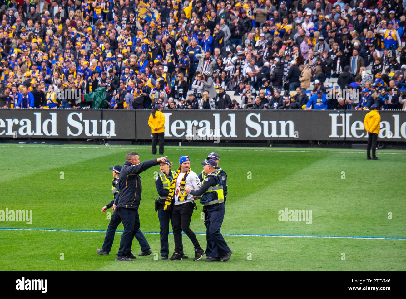 Arresto della polizia e scortando un invasore passo al 2018 AFL Grand Final di MCG Melbourne Victoria Australia. Foto Stock