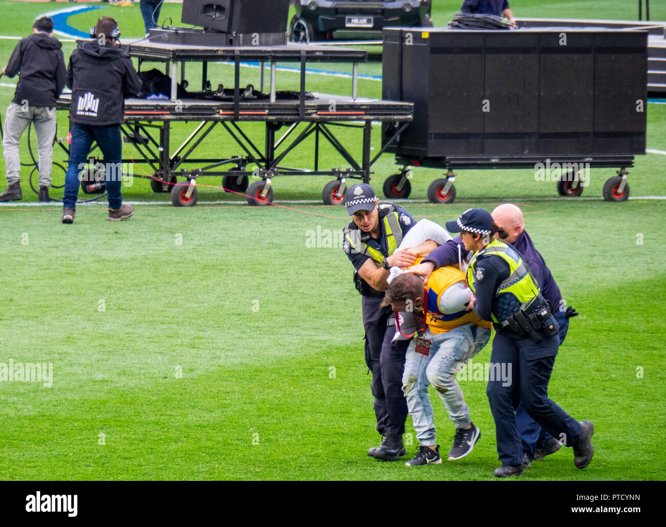 Arresto della polizia e scortando un invasore passo al 2018 AFL Grand Final di MCG Melbourne Victoria Australia. Foto Stock