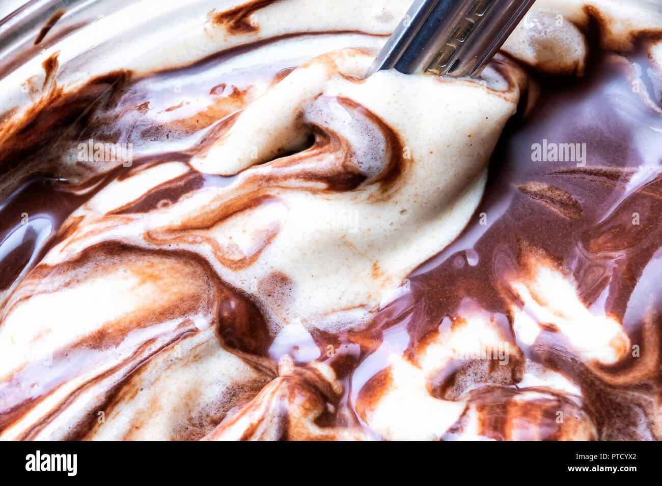 Servire morbido di vaniglia e gelato al cioccolato con marrone scuro una spruzzata di sciroppo di salsa closeup nella piastra, ciotola con cucchiaio Foto Stock