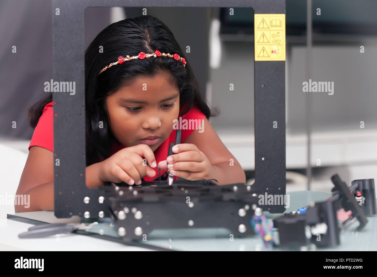 Ragazza giovane, 8 anni assemblaggio di una stampante 3D kit per stelo summer camp Foto Stock