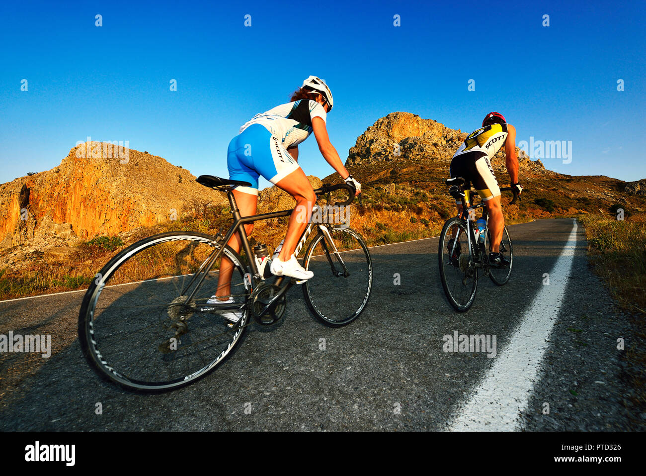Due corse del ciclo di ciclisti in salita su strada, Mesara altopiano vicino Zaros, Creta, Grecia Foto Stock