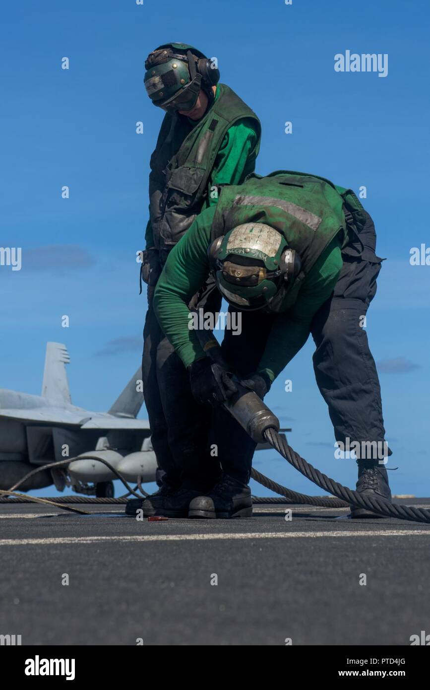 A SUD DEL PACIFICO (7 luglio 2017) di aviazione di Boatswain Mate (attrezzature) aviatori David Porter e Michael Dennis fissare un filo di arresto perno prima di operazioni di volo sul ponte di volo della Marina è distribuita portaerei USS Ronald Reagan (CVN 76). Ronald Reagan, il portabandiera del Carrier Strike gruppo 5, è di pattuglia NEGLI STATI UNITI 7 flotta area di operazioni a sostegno della sicurezza e della stabilità in Indo-Asia-regione del Pacifico. Foto Stock