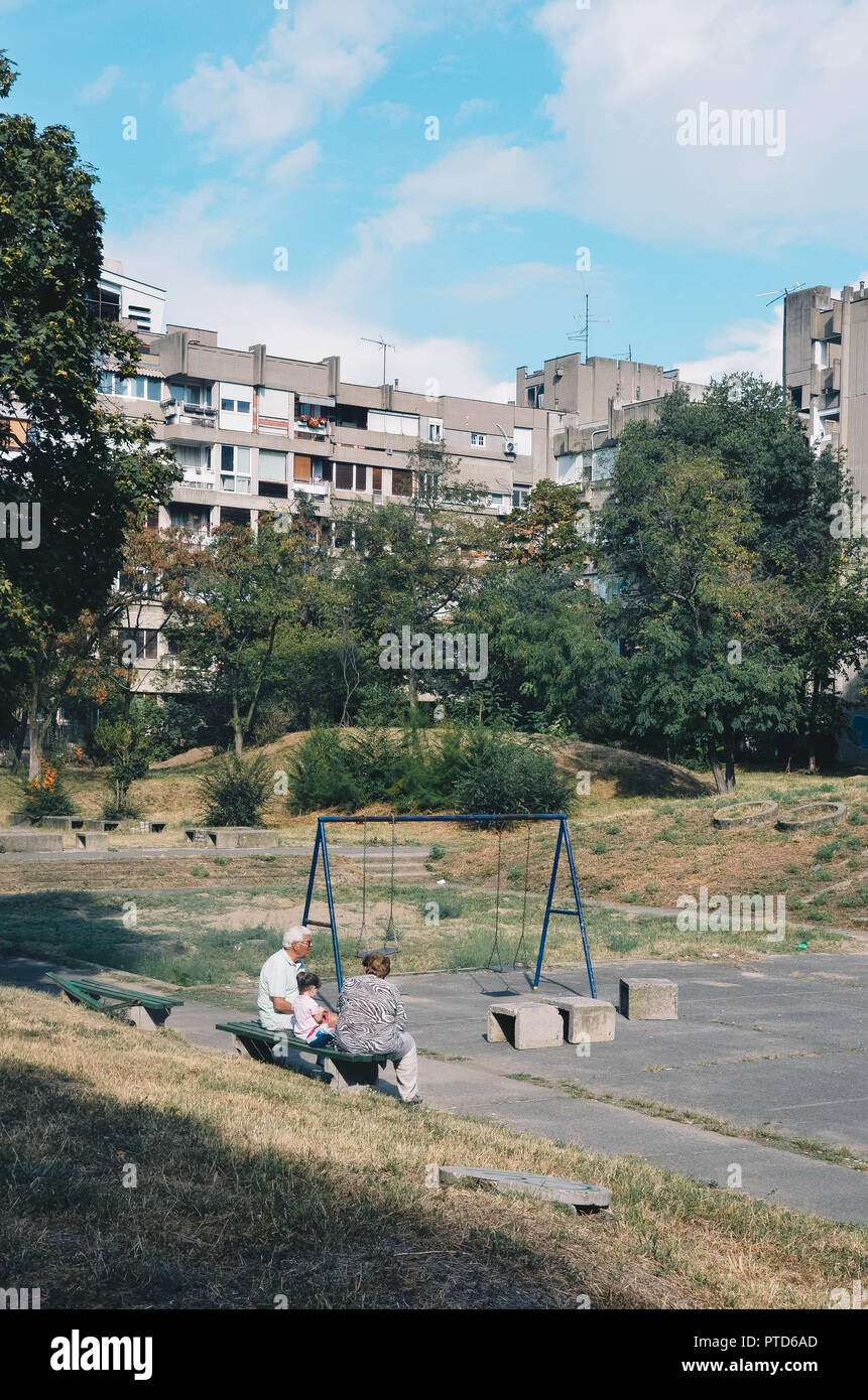 La gente seduta in un parco giochi nel blocco 23, Belgrado Nuova (Novi Beograd), Belgrado, Serbia, Balcani, Settembre 2018 Foto Stock