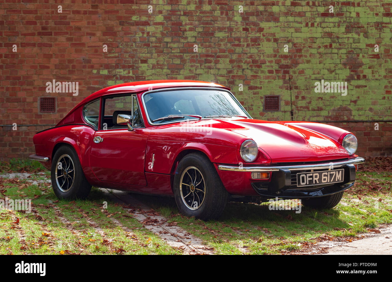 Triumph GT6 MK111 in rosso contro lo sfondo in muratura Foto Stock