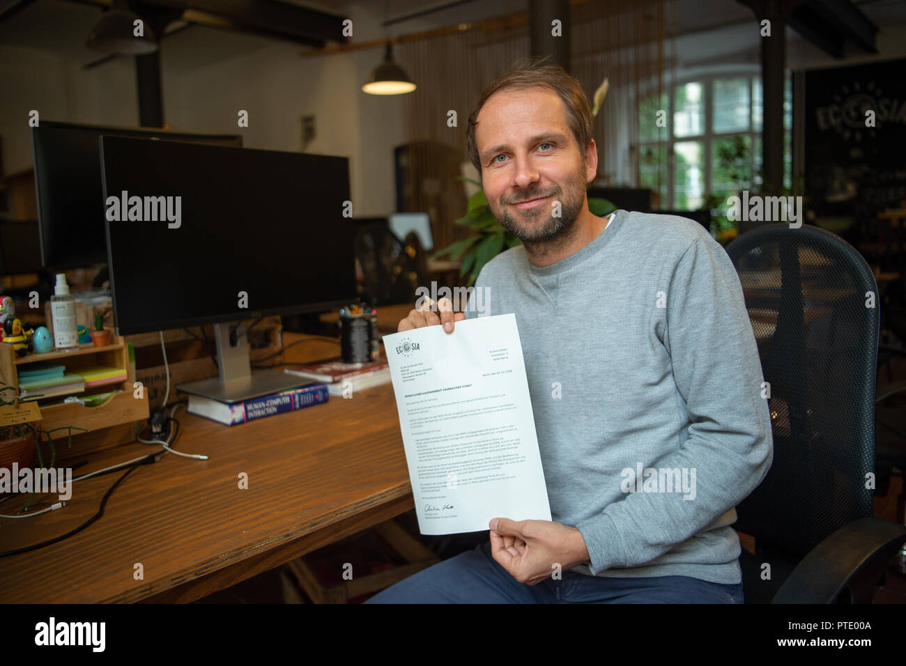 09 ottobre 2018, Berlin: Christian Kroll, fondatore del verde motore di ricerca 'Ecosia', contiene una lettera nella sua mano mostra RWE dell offerta per acquistare il Hambach foresta. Dopo la sosta temporanea di deforestazione nella foresta di Hambach, la società che si è impegnata per la tutela ambientale, ha presentato una offerta di acquisto del valore di un milione di euro per il gruppo energetico RWE. Foto: Arne Immanuel Bänsch/dpa Foto Stock