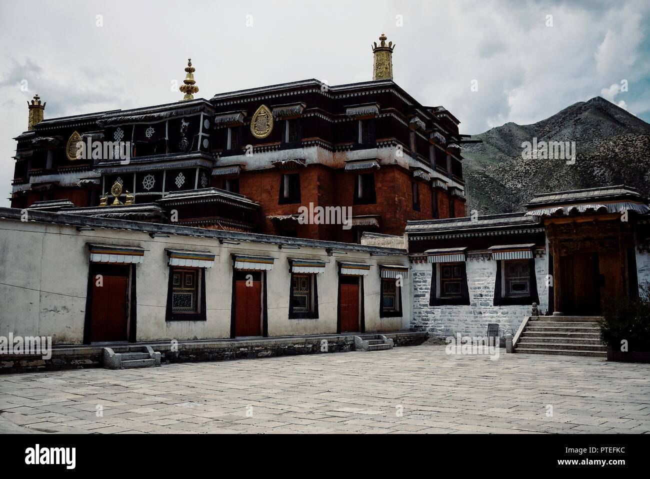 Monastero di Labrang, Xiahe, provincia di Gansu / Cina - 6 GIU 2011: tibetano tempio buddista edificio di fronte a una gamma di montagna picco Foto Stock