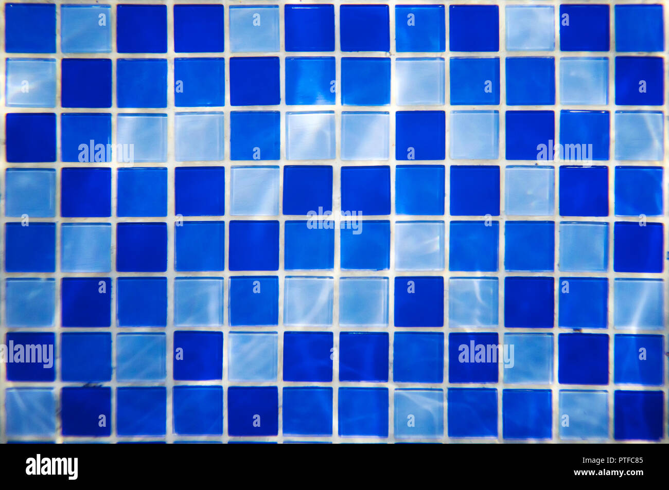 Disegno quadrato di blu e azzurro di piastrelle per il bagno le pareti e il pavimento o piscina design. L'acqua lampeggia su pareti piastrellate in un parco acquatico. Indo Foto Stock