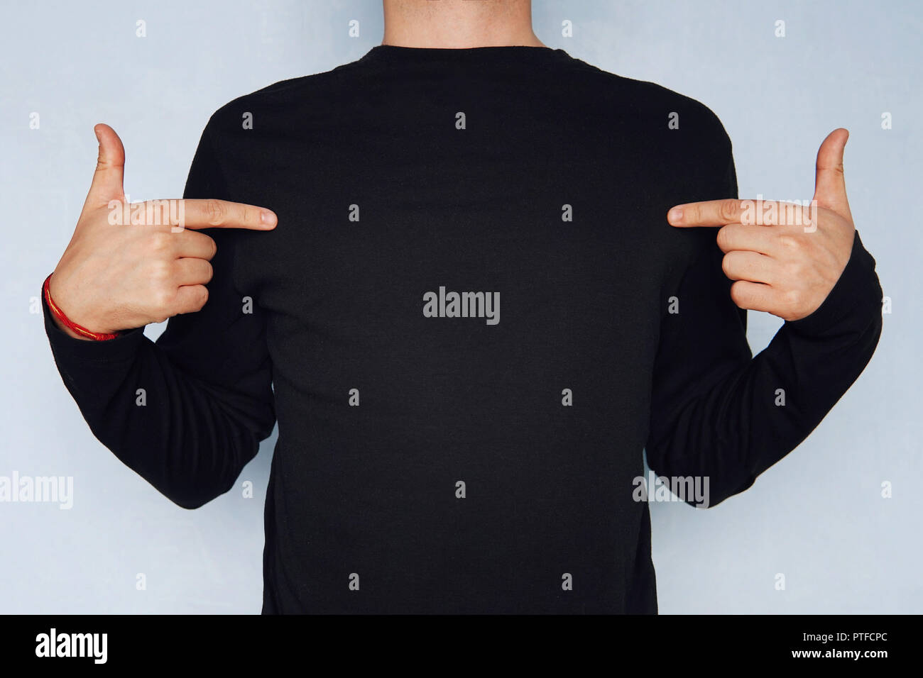 L'uomo puntando verso la sua t-shirt può essere usato come un abito modello  di disegno su uno sfondo blu. T-shirt con maniche lunghe nero. mocap per la  progettazione Foto stock - Alamy