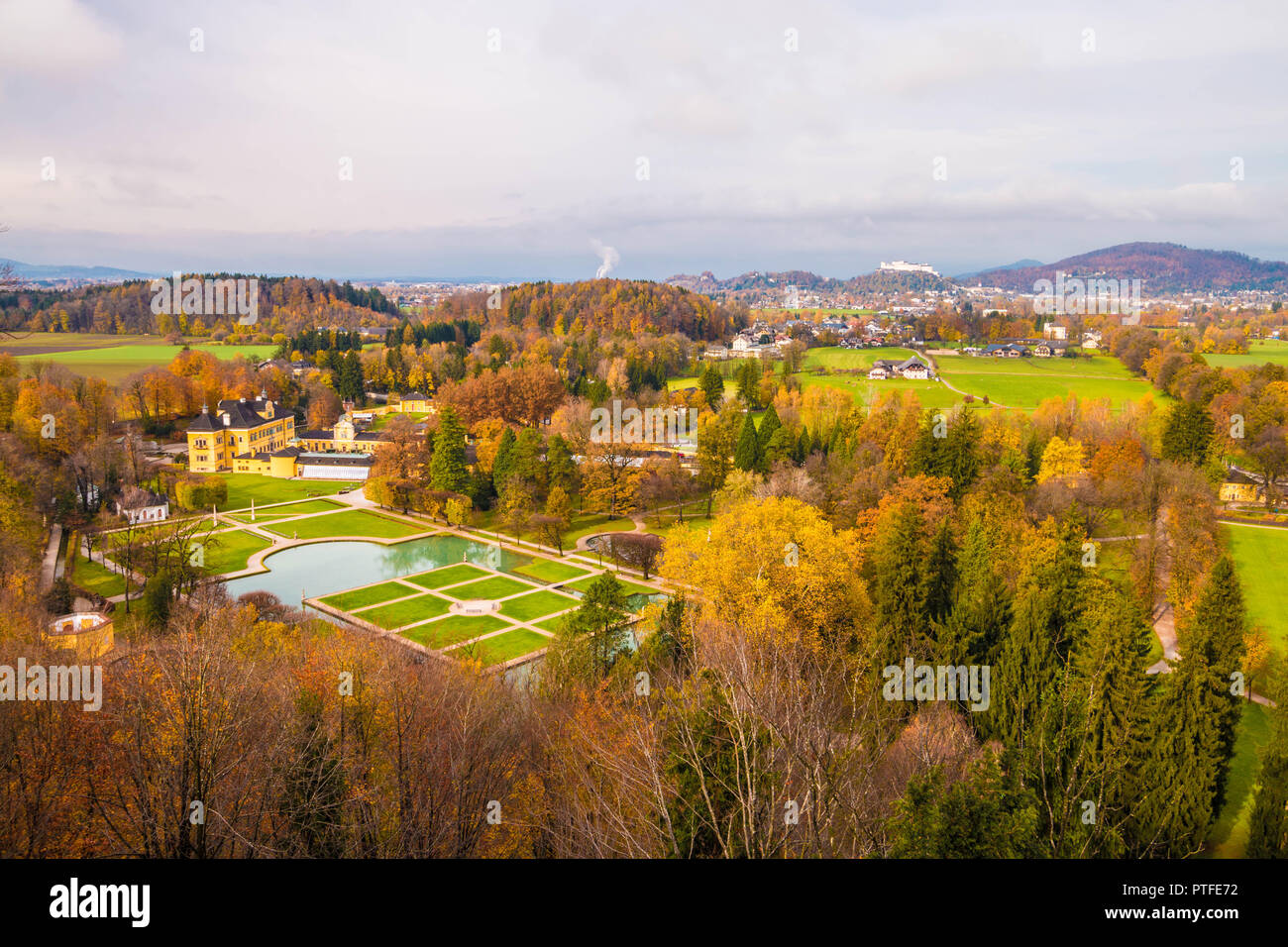 Vista panoramica del castello di Hellbrunn (Schloss Hellbrunn) e del parco in una bella giornata d'autunno. Il castello di Hohensalzburg visto sullo sfondo. Salisburgo, Austria. Foto Stock