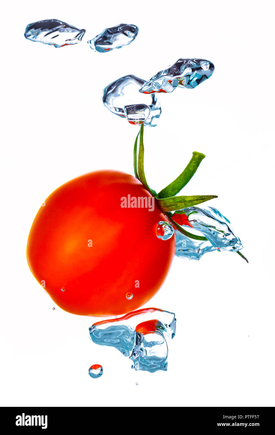 Little cherry pomodoro schizzi in acqua con bolle di aria Foto Stock
