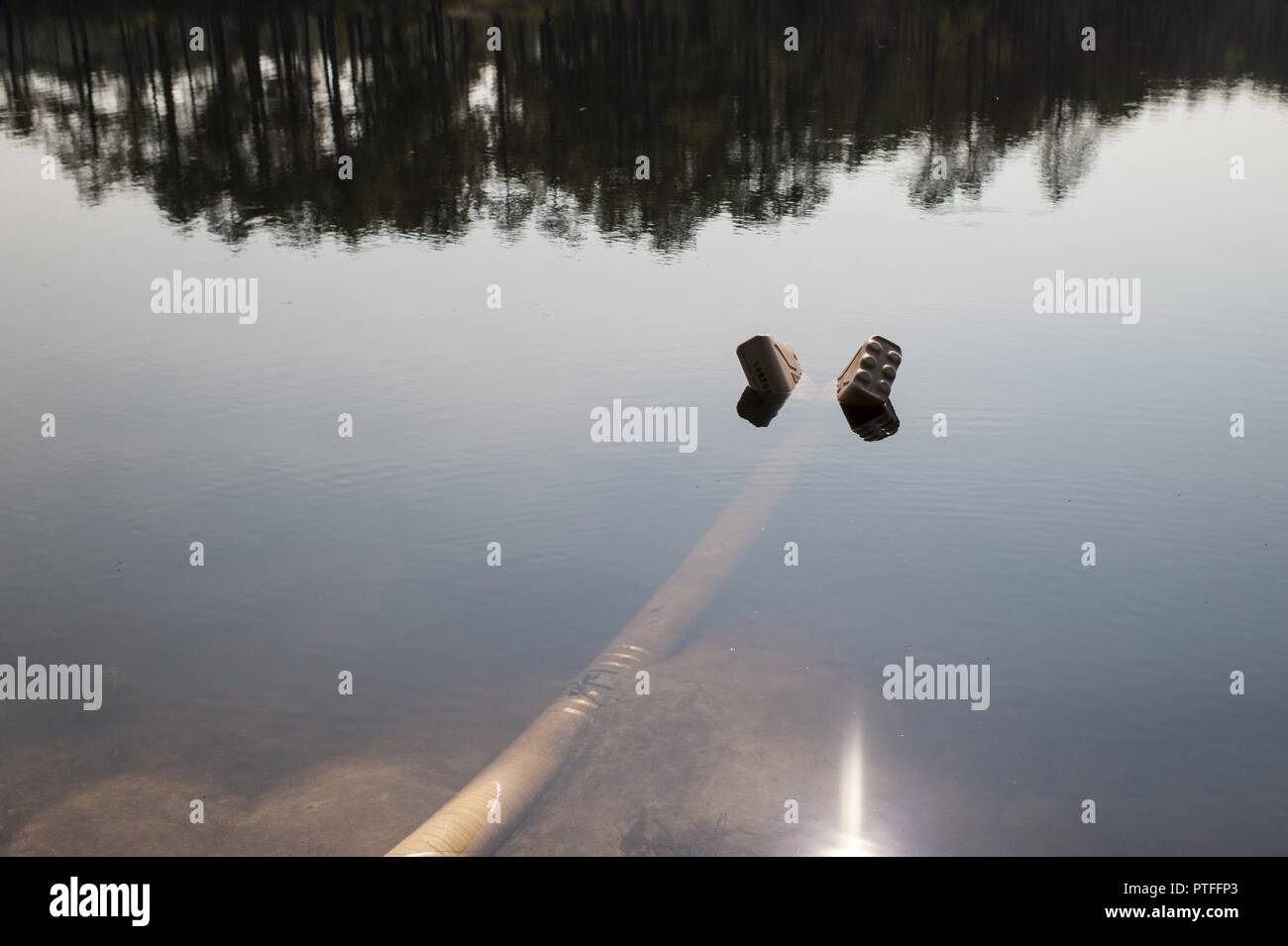 Una coppia di svuotare contenitori di acqua e mantenere una succhieruola a galla sul lago MacArthur per la pipeline terrestre del sistema di distribuzione durante QLLEX 2017, 21 luglio a Fort Bragg, NC. QLLEX, corto per il Quartermaster Logistica liquido di esercizio, è l'U.S. La riserva di esercito del premier esercizio di preparazione per il carburante e la distribuzione d'acqua. Questo anno di QLLEX non è solo una dimostrazione completa della capacità di combattere la prontezza e la letalità di America's Army riserva per mettere il combustibile e l'acqua in cui è più necessaria - per i veicoli e le mani della guerra-combattente e unità di manovra - ma anche ulteriori esercizi di interoperabilità Foto Stock