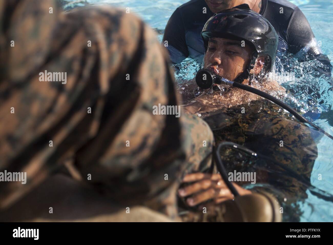 Un U.S. Marine pratiche utilizzando un'emergenza sistema di respirazione durante l'acqua poco profonda formazione Egress, Marine Corps base Hawaii, luglio 21, 2017. Nel caso di un assalto anfibio veicolo che affonda sommersa, veicolo di temporizzazione e di formazione subacquea formazione Egress sono di vitale importanza dei programmi di formazione che prepara i Marines e marinai sulla fuga in modo sicuro il veicolo. Foto Stock