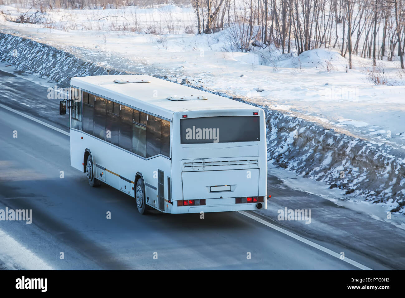 Bus è la guida su una strada di campagna in inverno Foto Stock