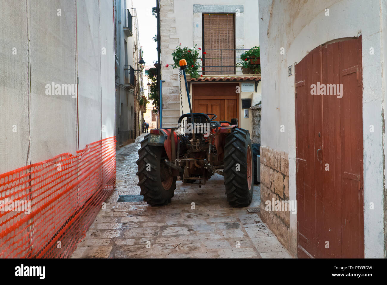 Palo del Colle,l'Italia,08/08/2018; trattore agricolo nel vecchio centro di Palo del Colle una mattina a mezzogiorno,il quale è parcheggiata fuori casa. Foto Stock