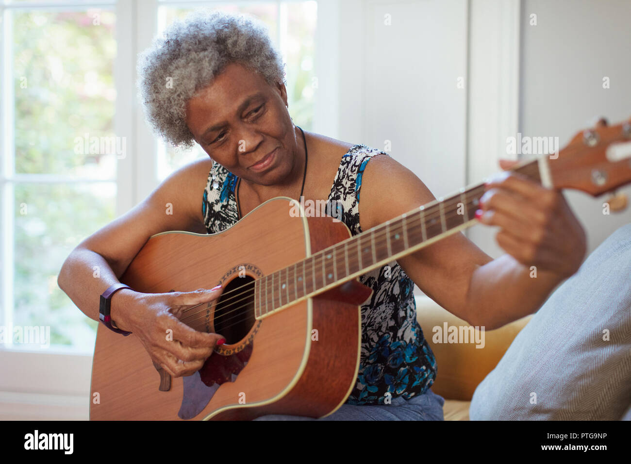 Attiva donna senior a suonare la chitarra Foto Stock