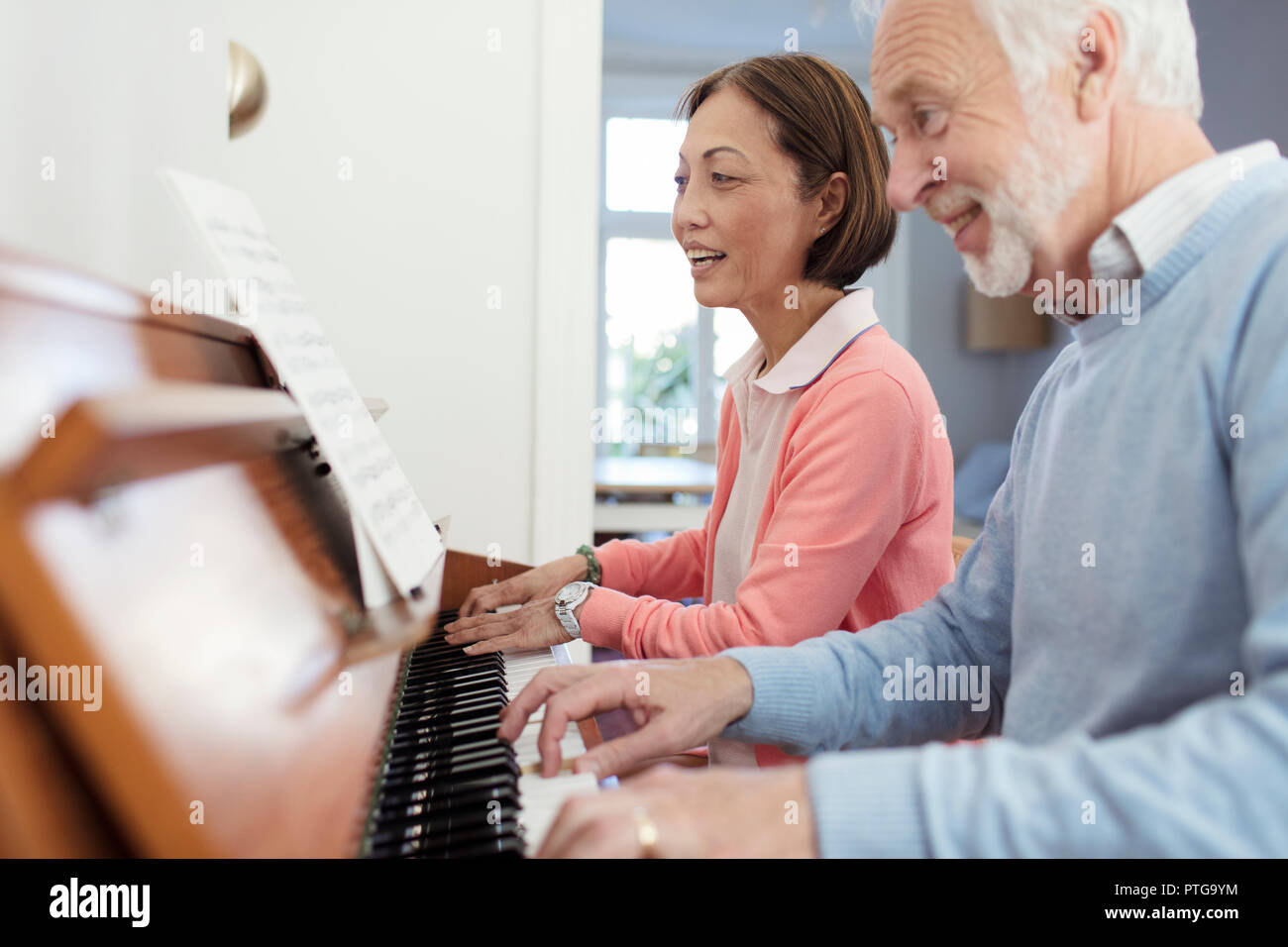 Attivo coppia senior suonando piano Foto Stock