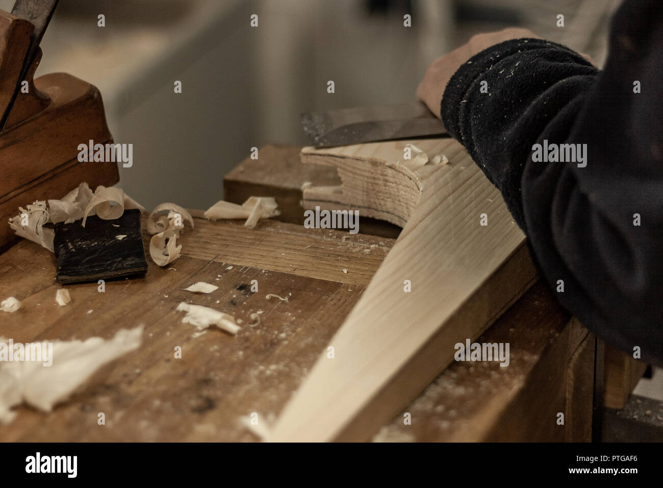 Eco-friendly falegname del negozio. Dettagli e concentrarsi sulla consistenza del materiale, segatura e ruspe o scalpelli, pur rendendo le gambe per il serraggio di un dado 24. Foto Stock