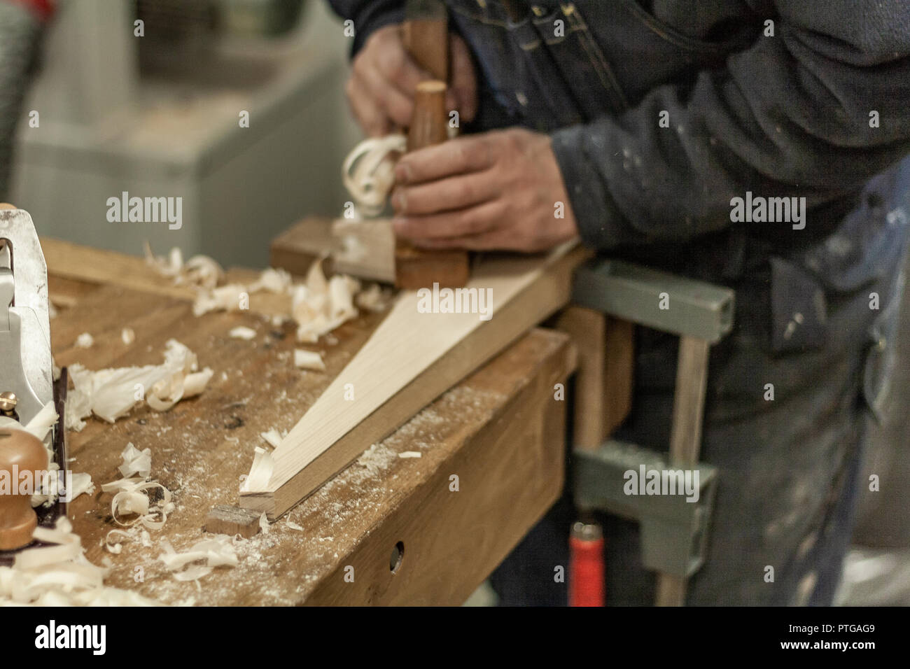 Eco-friendly falegname del negozio. Dettagli e concentrarsi sulla consistenza del materiale, segatura e ruspe o scalpelli, pur rendendo le gambe per il serraggio di un dado 24. Foto Stock