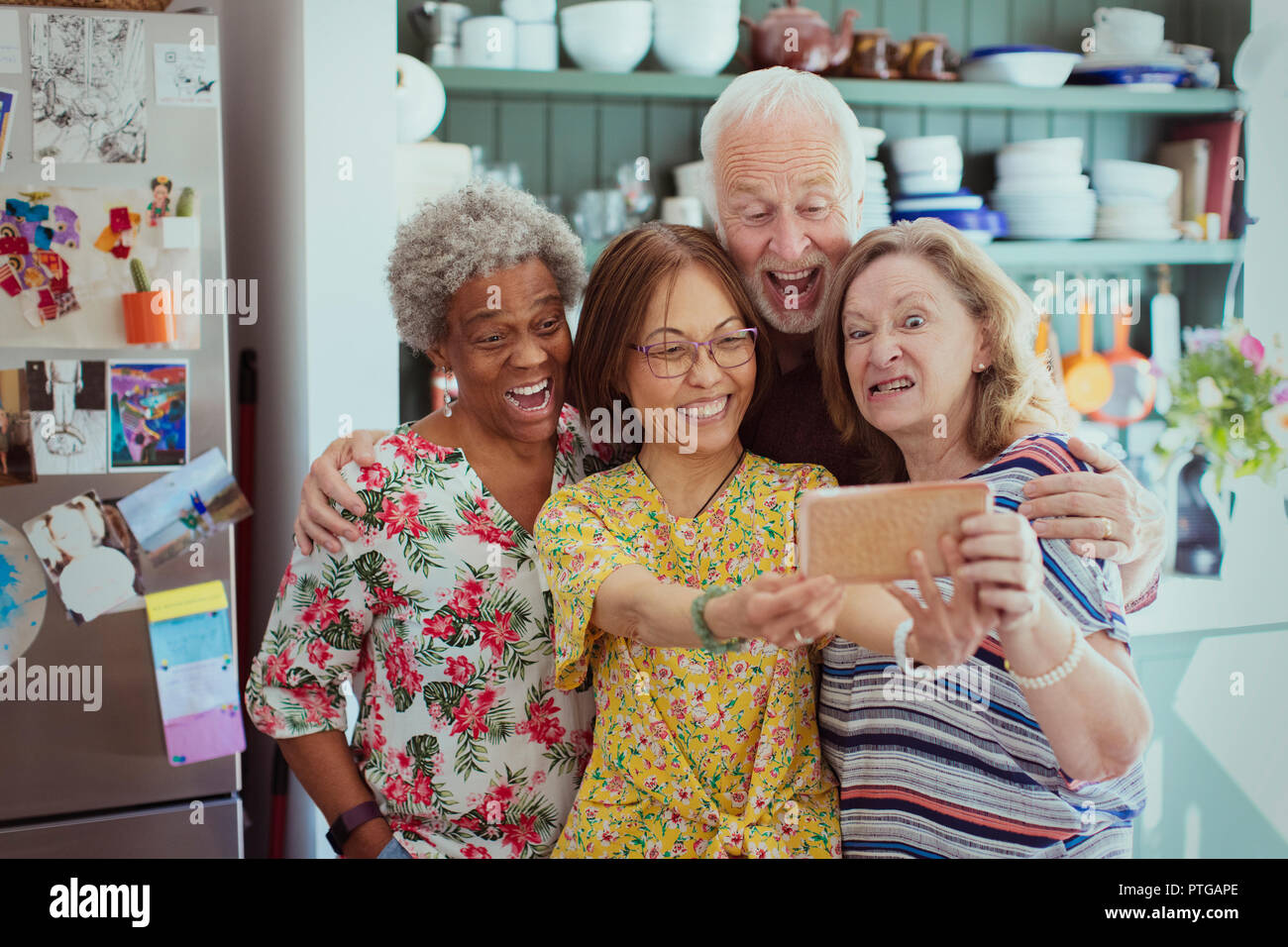 Felice, giocoso active seniors selfie prendendo con la fotocamera del telefono, rendendo silly volti Foto Stock