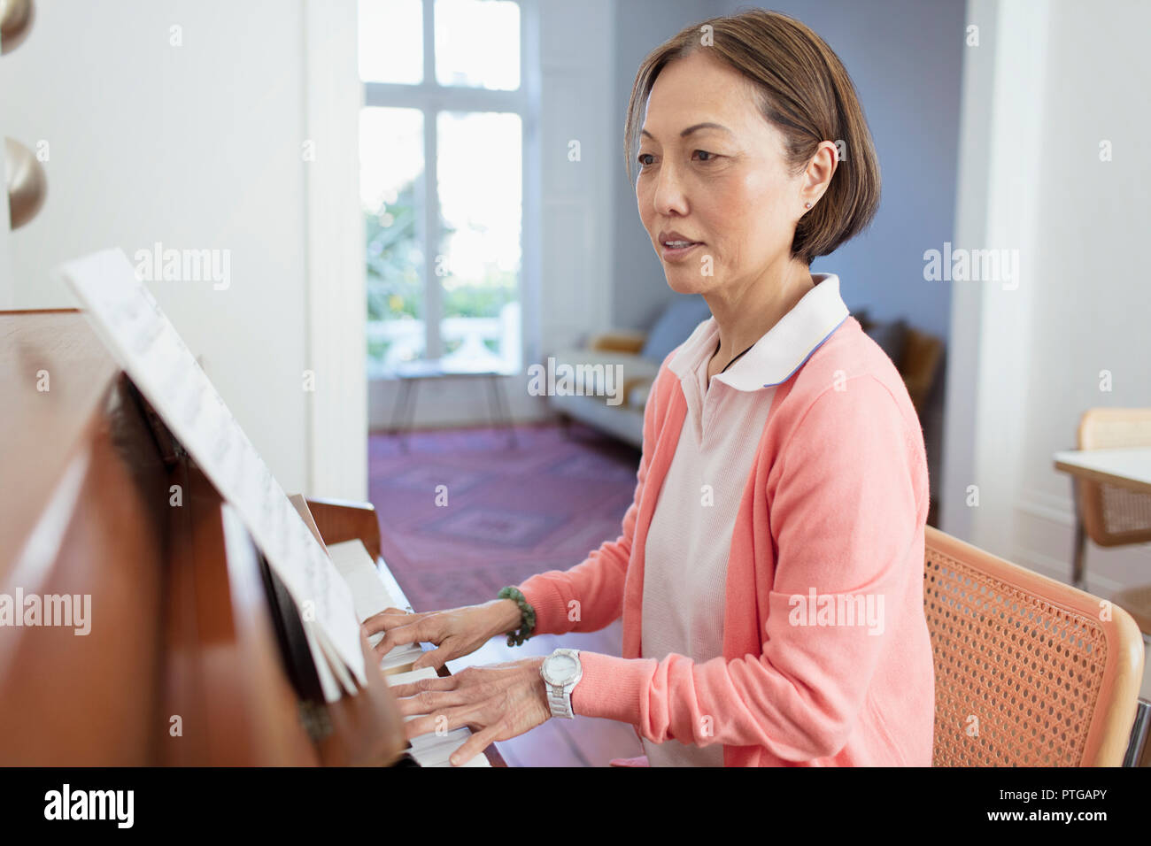 Attiva donna senior suonando piano Foto Stock