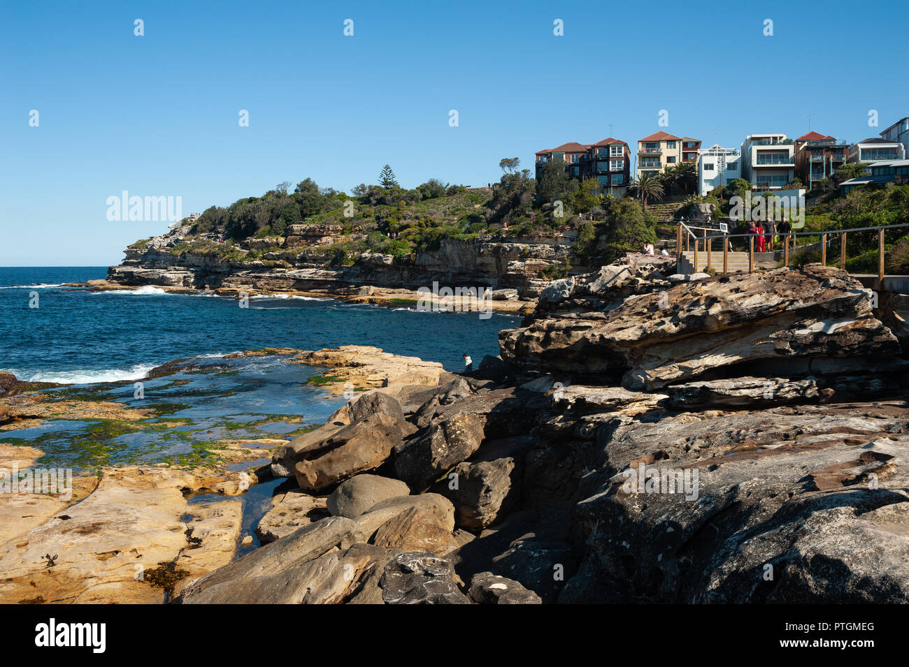 21.09.2018, Sydney, Nuovo Galles del Sud, Australia - Case di sedersi su uno sperone roccioso a picco sul mare lungo la Bondi a Bronte passeggiata costiera. Foto Stock