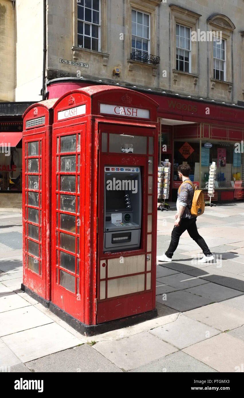 Un rosso classico casella telefono che è stato convertito in una cassa di ATM in Bath Regno Unito. 2018. Foto Stock