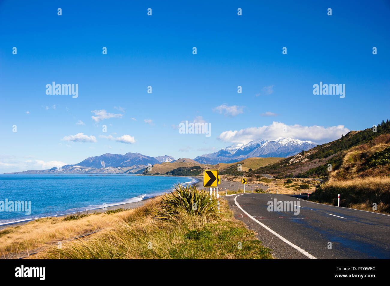 Autostrada statale 1, iconico percorso costiero vicino a Kaikoura, Nuova Zelanda, uno dei top costieri nel mondo. Montagne innevate incontra il mare, il cielo e la strada Foto Stock