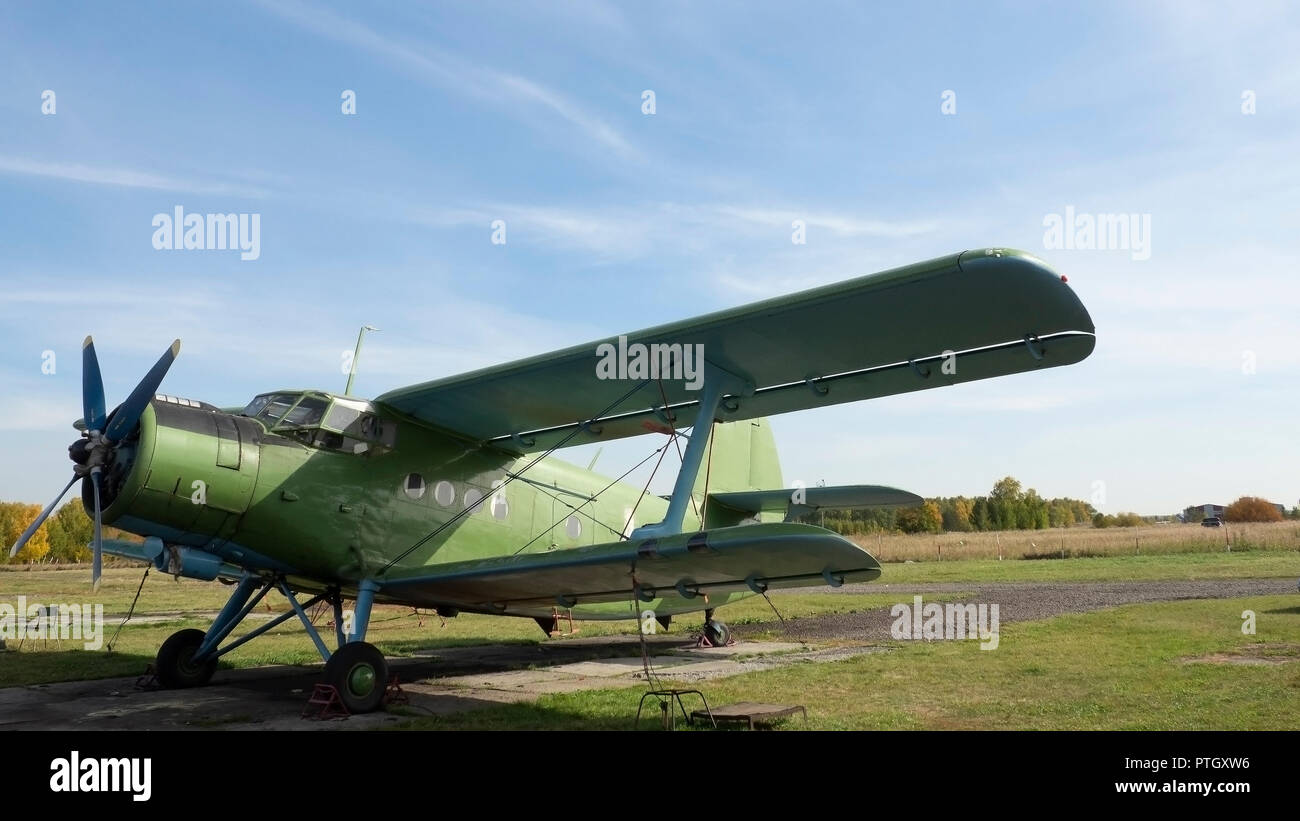 Vista del velivolo classico sull'aviosuperficie erbosa; aerei dopo il volo con casi su eliche e altri elementi; verde aerei militari sul Foto Stock