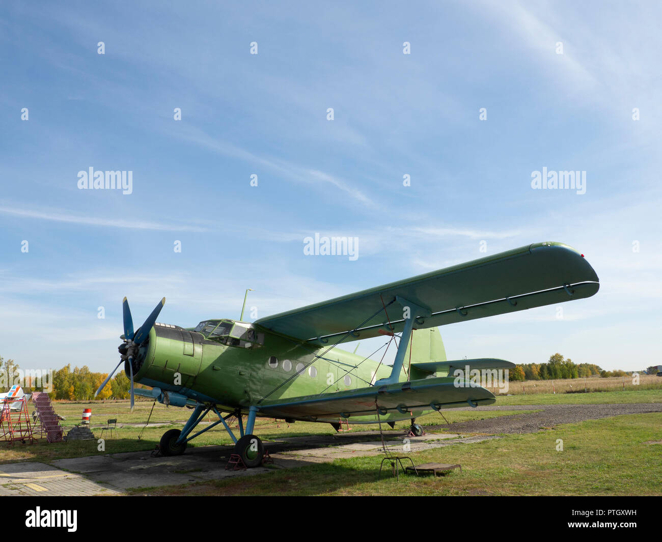 Vista del velivolo classico sull'aviosuperficie erbosa; aerei dopo il volo con casi su eliche e altri elementi; verde aerei militari sul Foto Stock