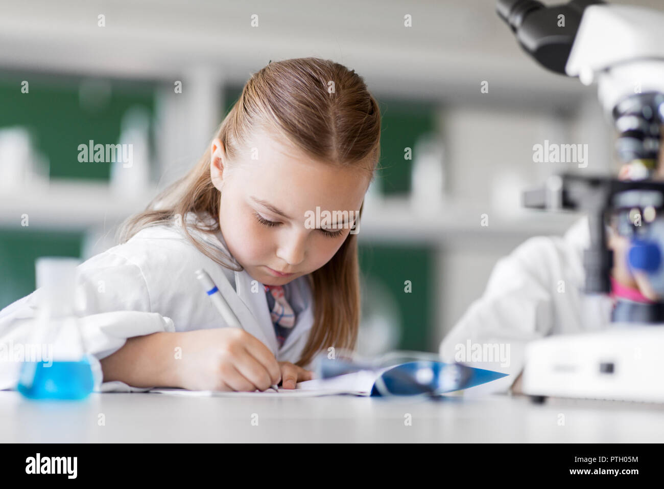Ragazza che studia chimica in laboratorio scolastico Foto Stock