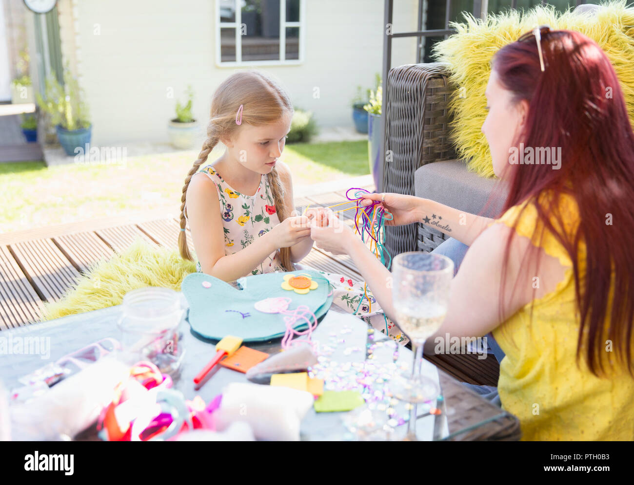 Madre e figlia facendo del progetto CRAFT sul patio Foto Stock