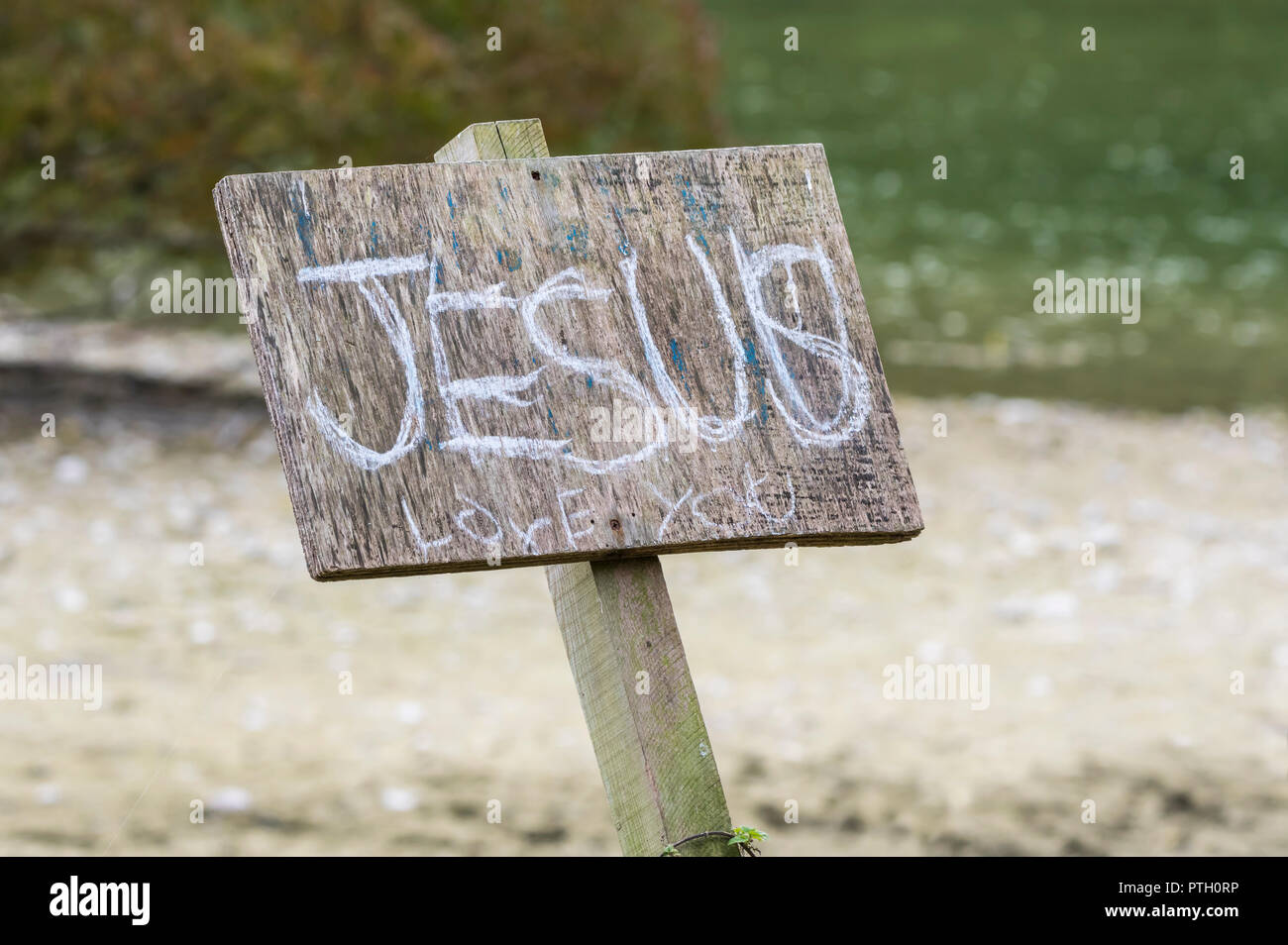 Segno esterno con graffiti dicendo "Gesù vi ama", un messaggio religeous per promuovere la fede cristiana nel Regno Unito. Foto Stock