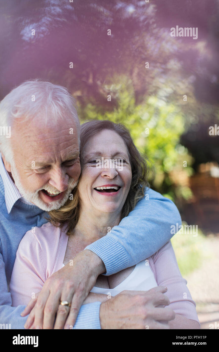 Affettuosa, sorridente coppia senior avvolgente Foto Stock