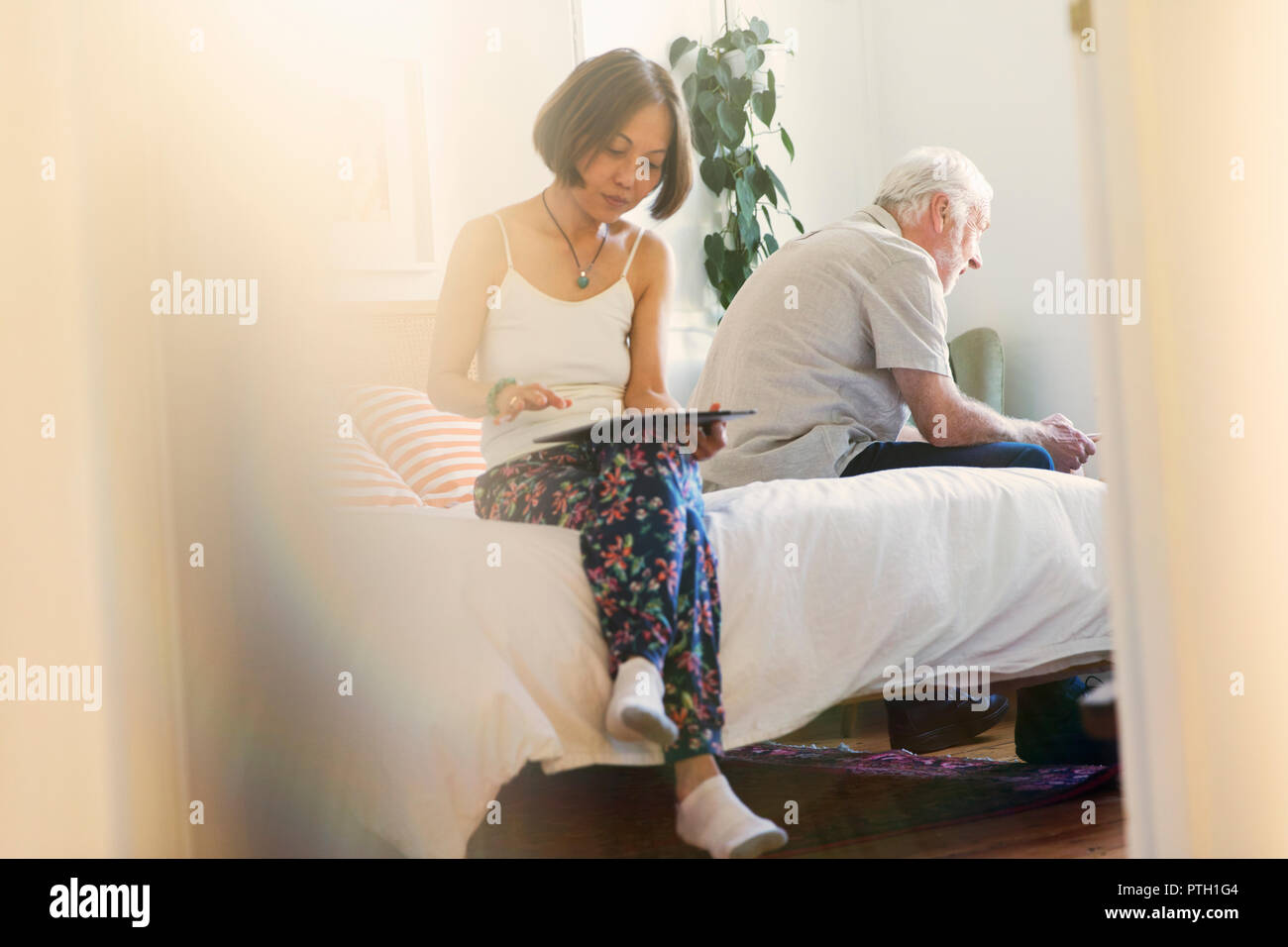 Coppia senior utilizzando compresse digitale in camera da letto Foto Stock