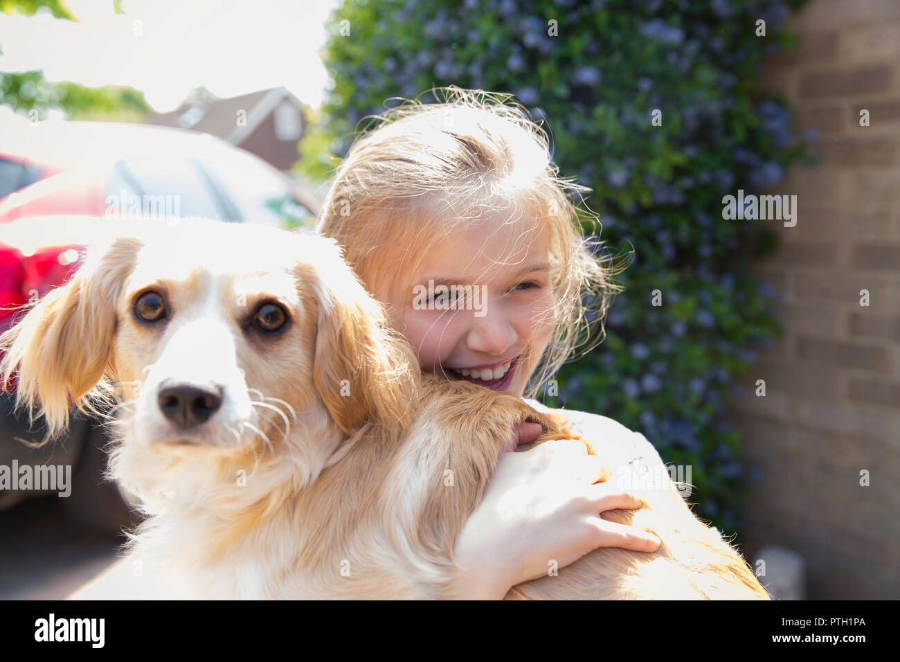 Felice ragazza abbracciando il cane Foto Stock