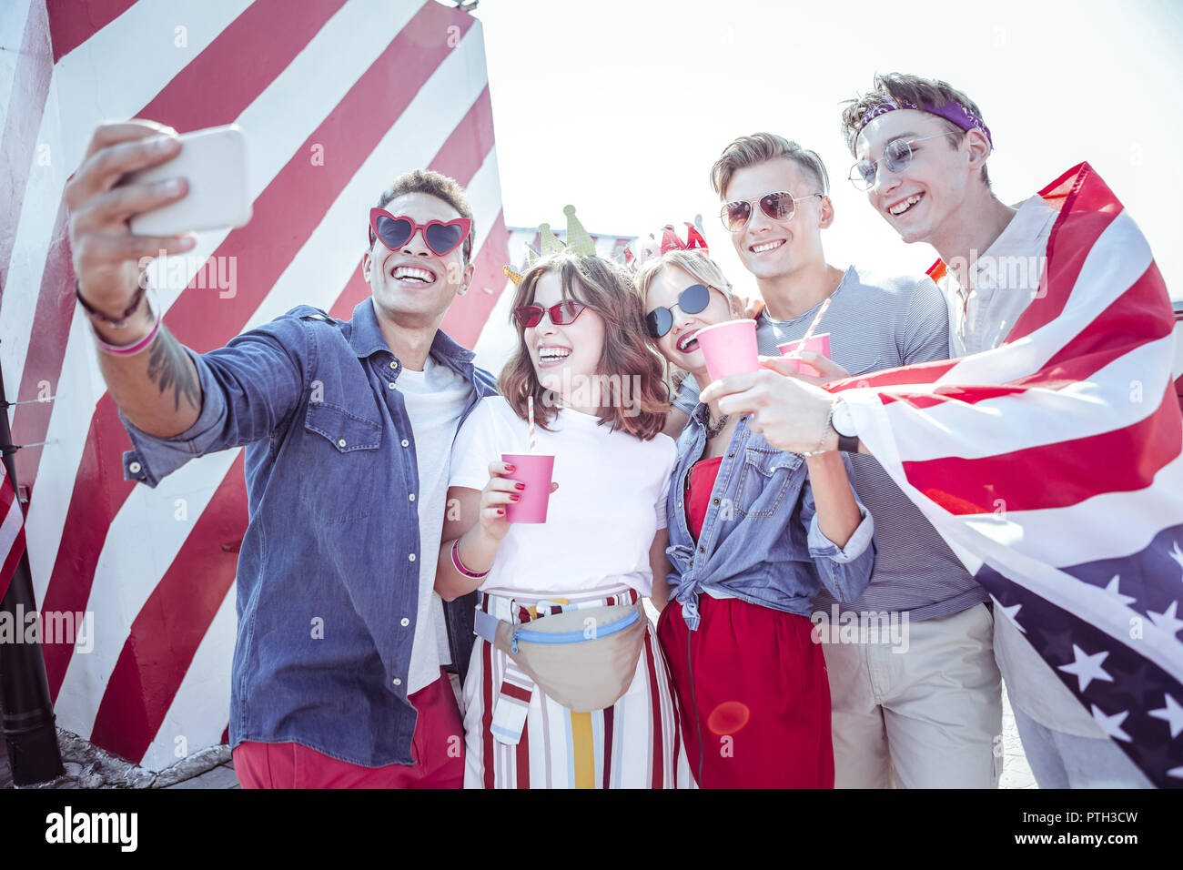 Allegro uomo internazionale in piedi vicino ai suoi amici Foto Stock