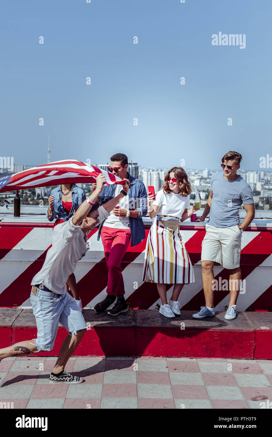 Gioiosa giovane uomo che corre con bandiera americana Foto Stock