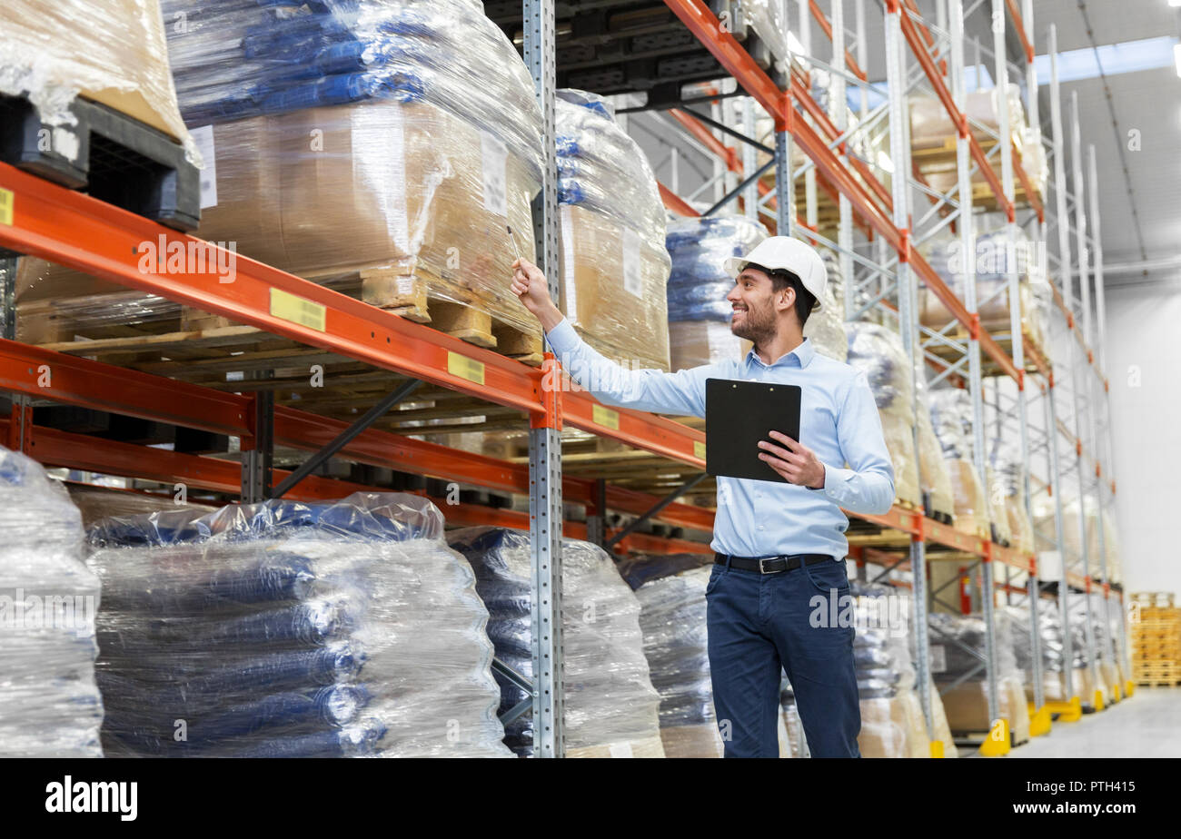 Imprenditore nel casco con appunti a magazzino Foto Stock