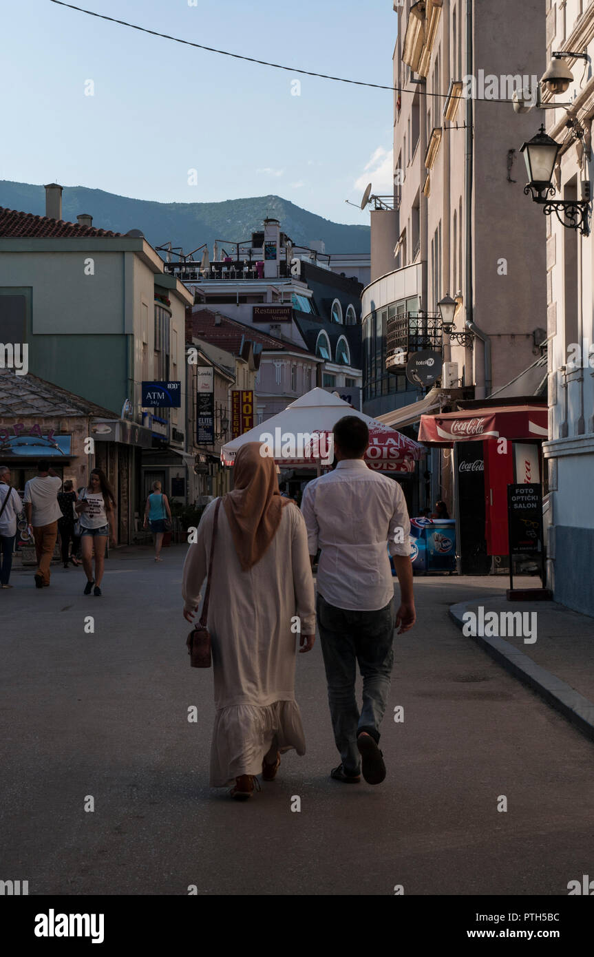 La Bosnia ed Erzegovina, Europa: una donna musulmana velata camminando con il suo marito per le strade della città di Mostar Foto Stock