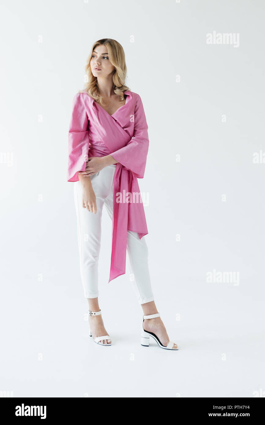 Considerato giovane donna in rosa camicetta in posa isolato su bianco Foto Stock
