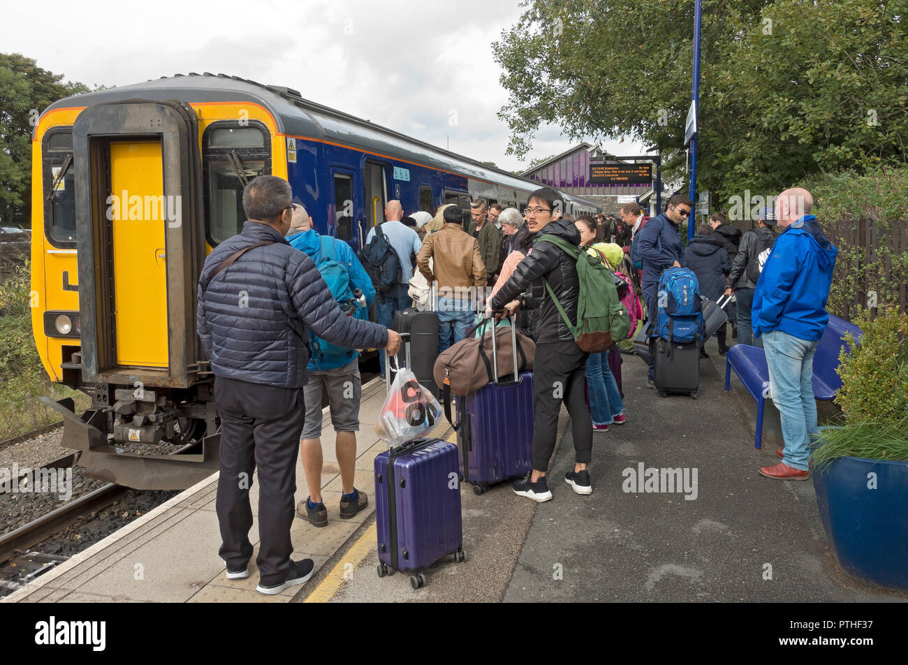 Passeggeri persone turisti imbarco salire a bordo del treno nord alla stazione ferroviaria di Windermere Cumbria Inghilterra Regno Unito Regno Unito Gran Bretagna Foto Stock