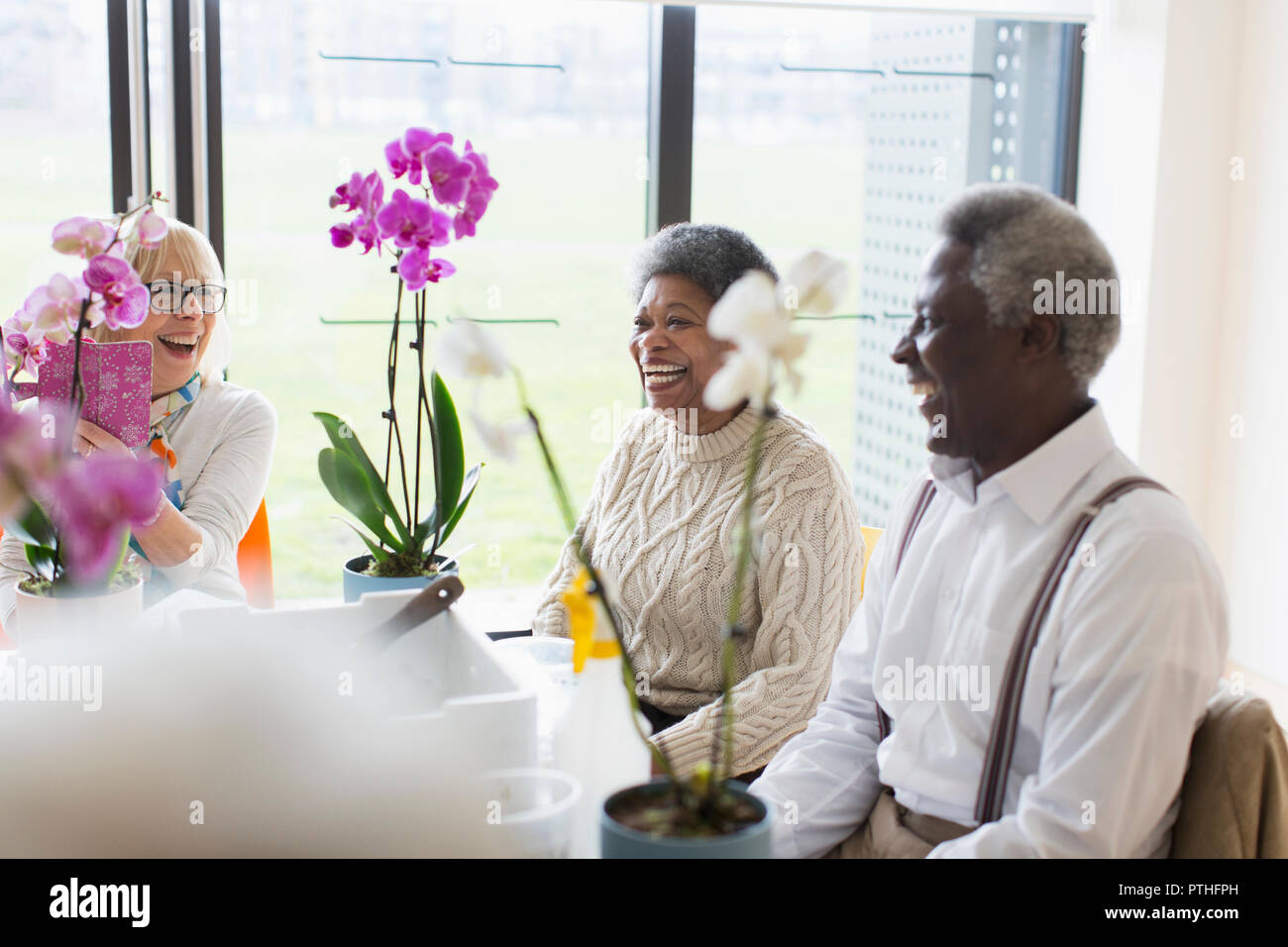 Felice active seniors godendo di decorazione floreale di classe Foto Stock