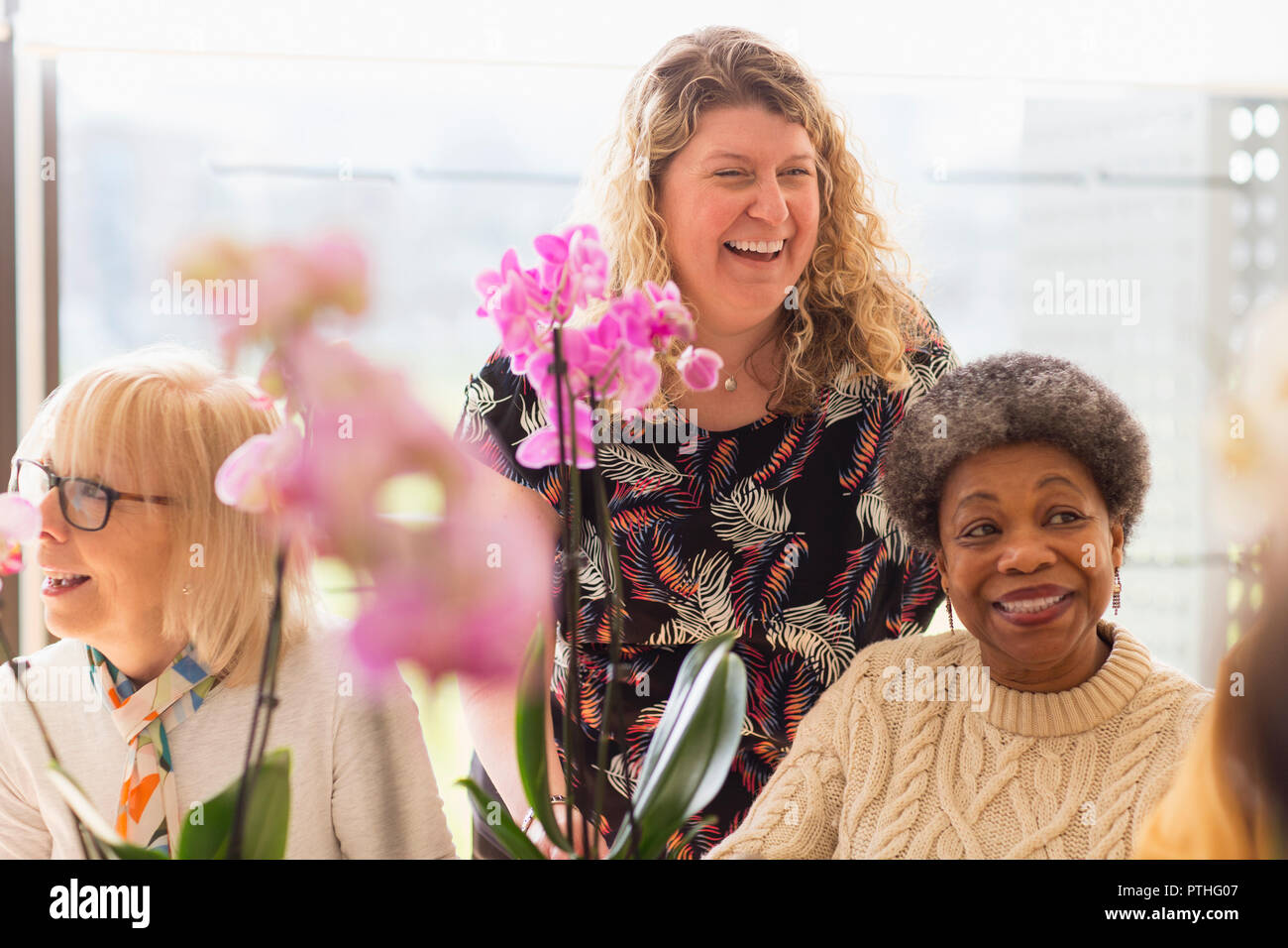 Felice e istruttori Seniors attiva godendo di decorazione floreale di classe Foto Stock