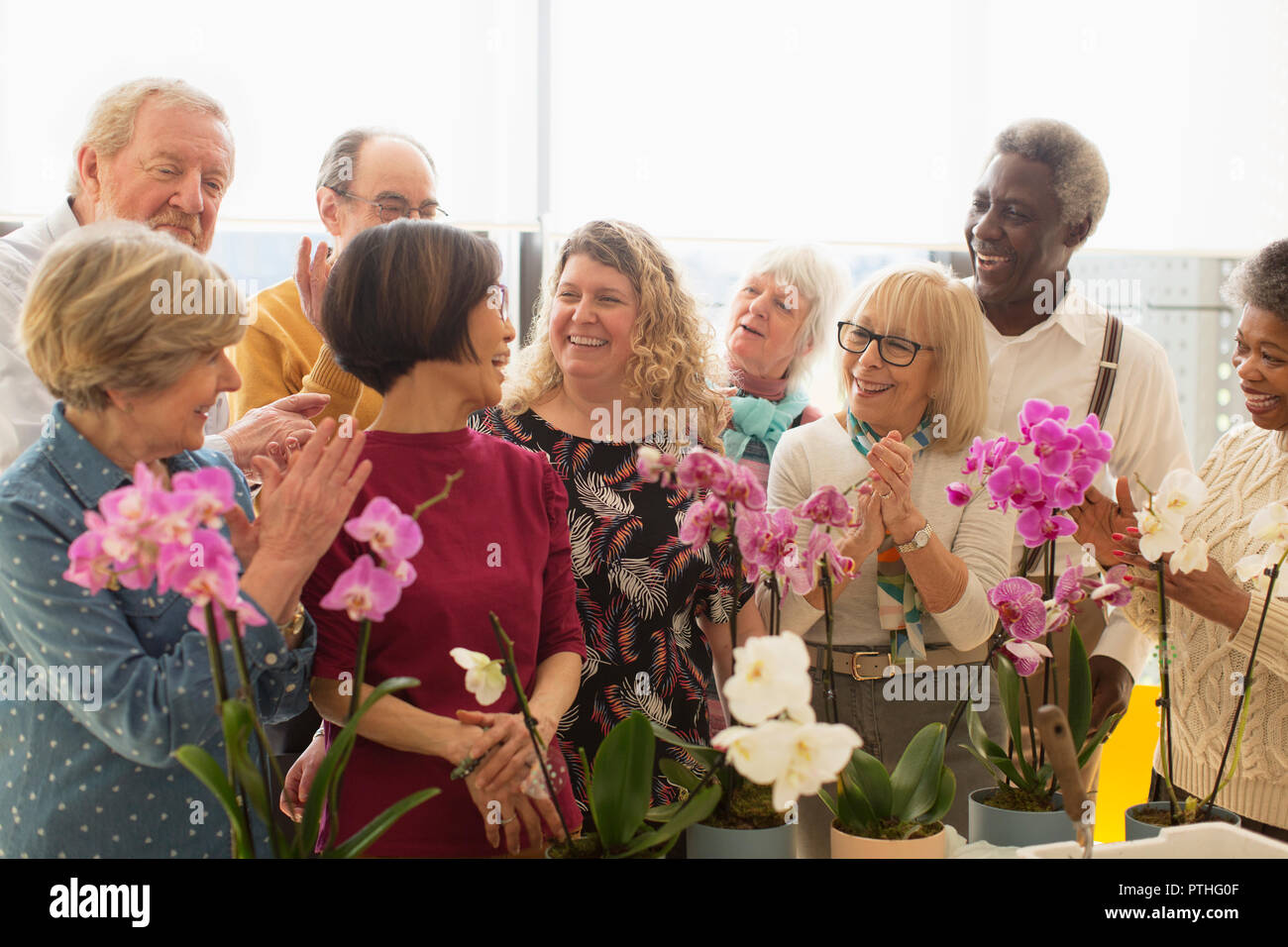 Felice active seniors godendo di decorazione floreale di classe Foto Stock