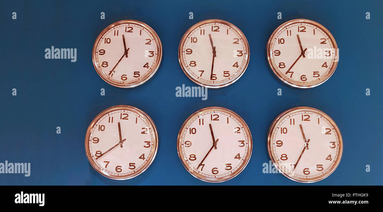 Sei orologi da parete con dodici ore faccia su sfondo blu Foto Stock