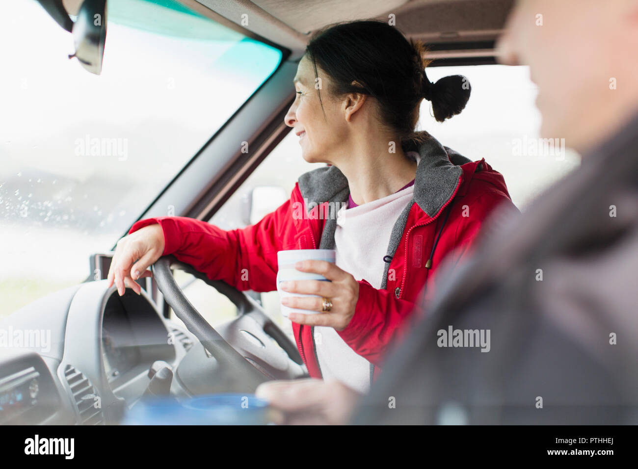 Donna con caffè motore di guida home Foto Stock