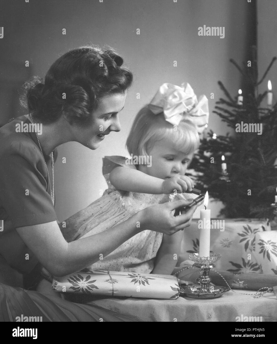 Natale nel 1940s. Una madre e figlia è rendere bella regali di Natale. Essi sono l'aggiunta di un sigillo di cera sul pacchetto, pehaps con un timbro in esso dicendo Buon Natale. La Svezia 1940s Foto Stock