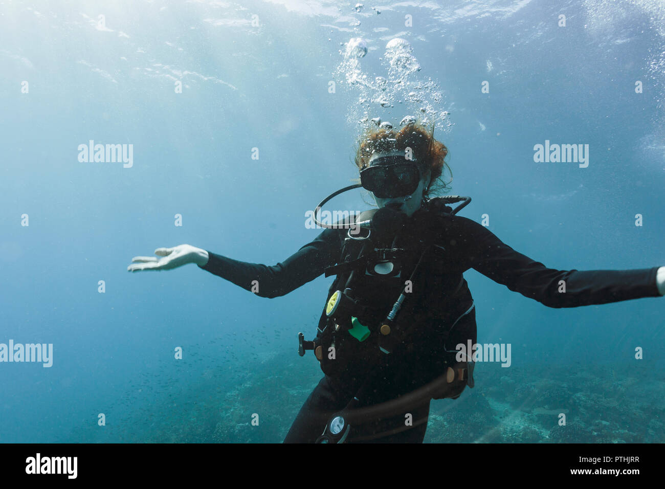 Ritratto di giovane donna scuba diving subacquei con le braccia aperte Foto Stock